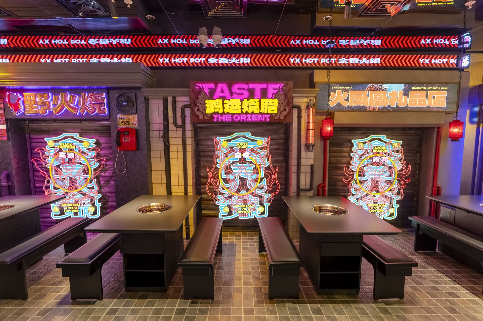 Neon signage and built-in hotpot tables in an Asian barbecue restaurant