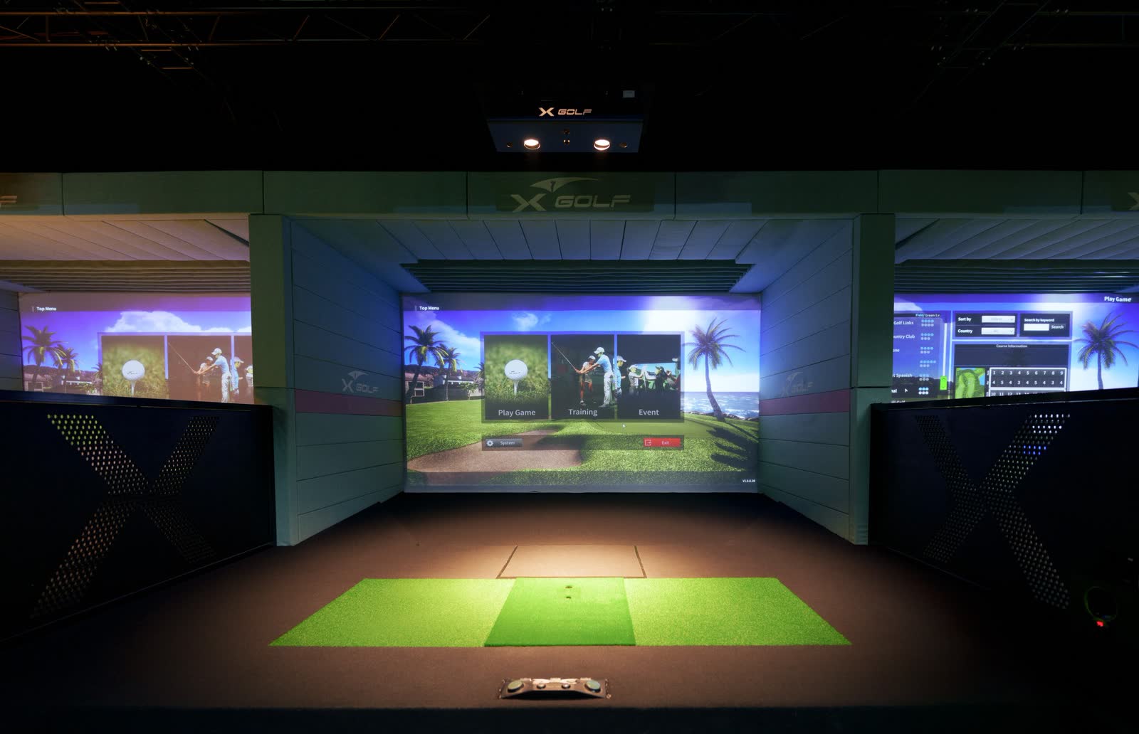 Golf simulator bays lit for play in an XGOLF venue