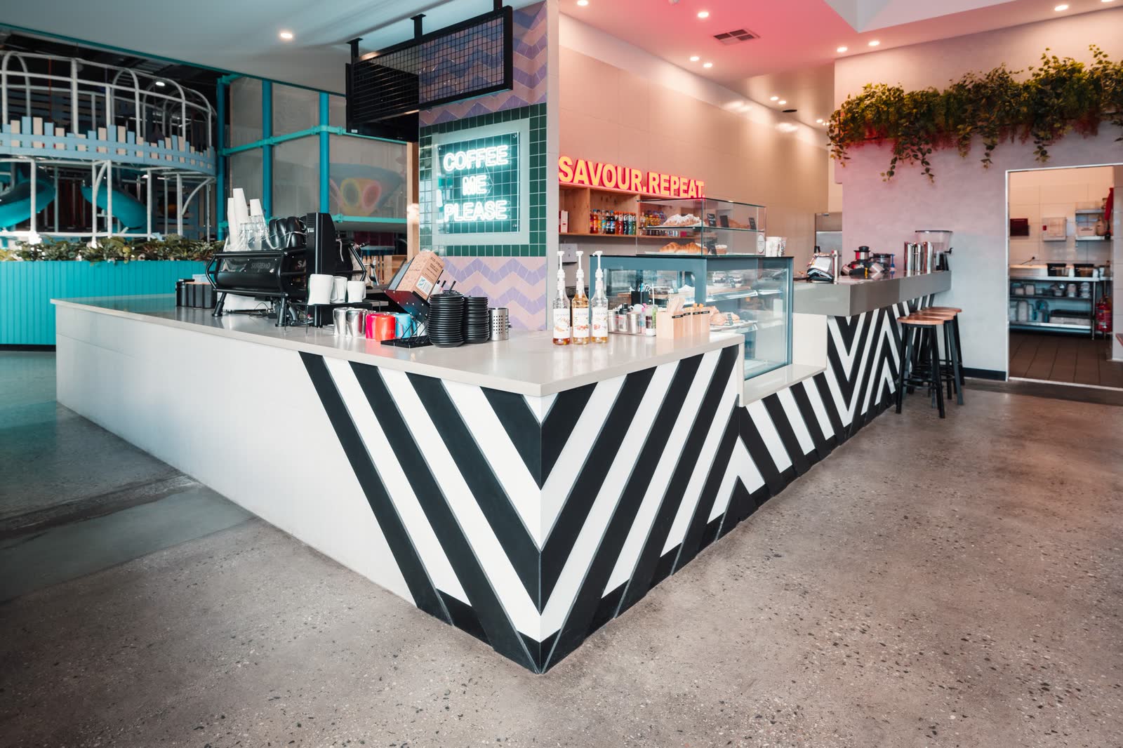 A cafe counter with a bold black and white chevron front in a family venue