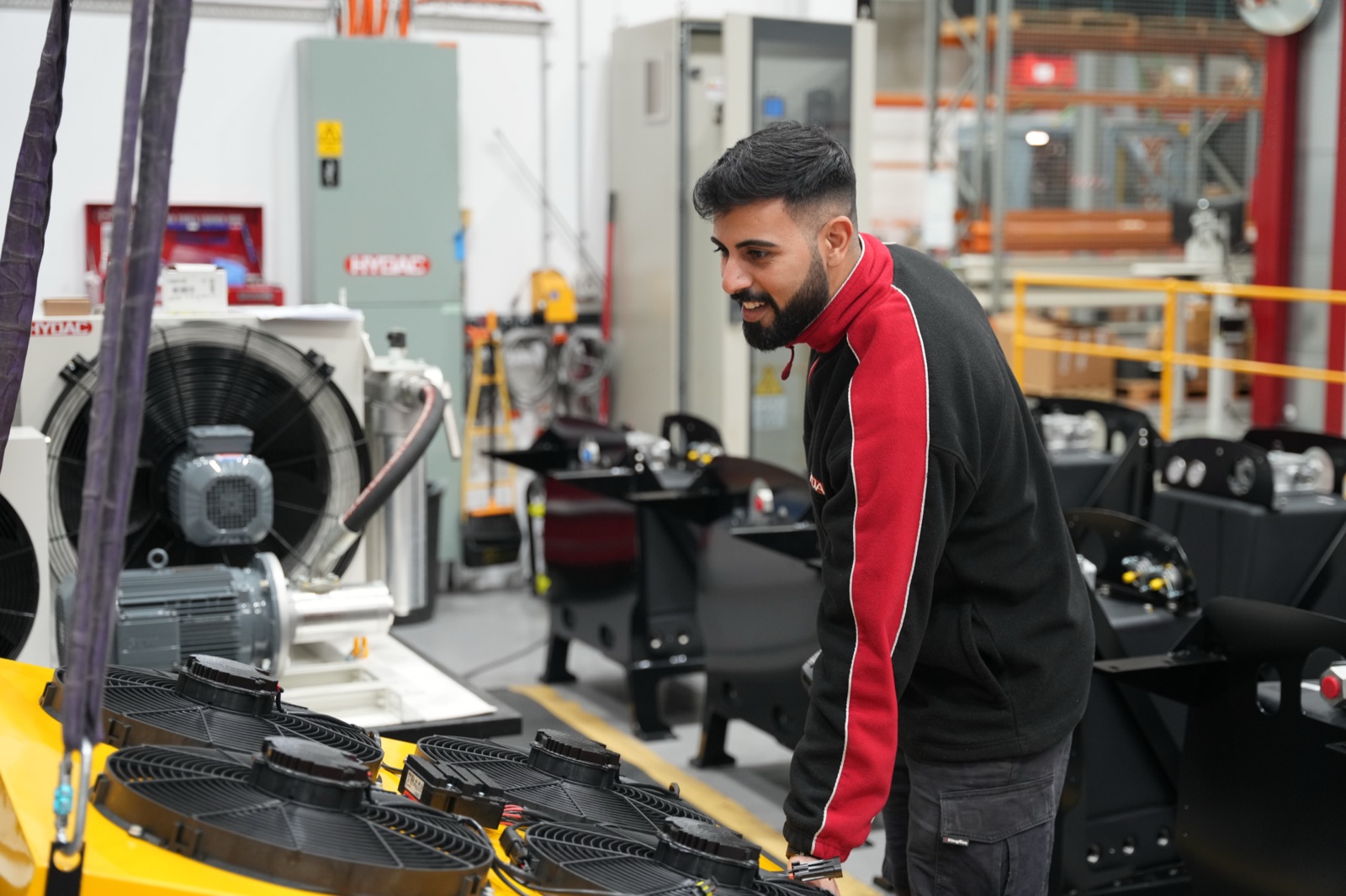 A technician working on hydraulic assemblies at the workshop bench