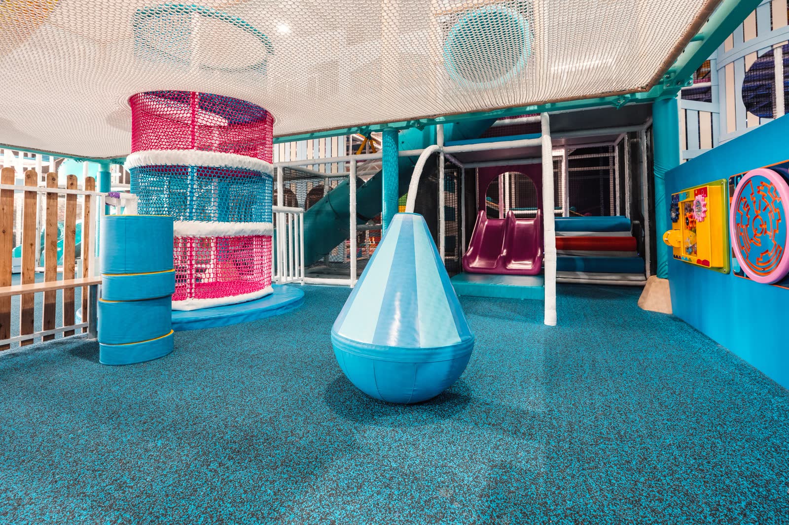 A brightly coloured indoor play centre with slides and climbing nets