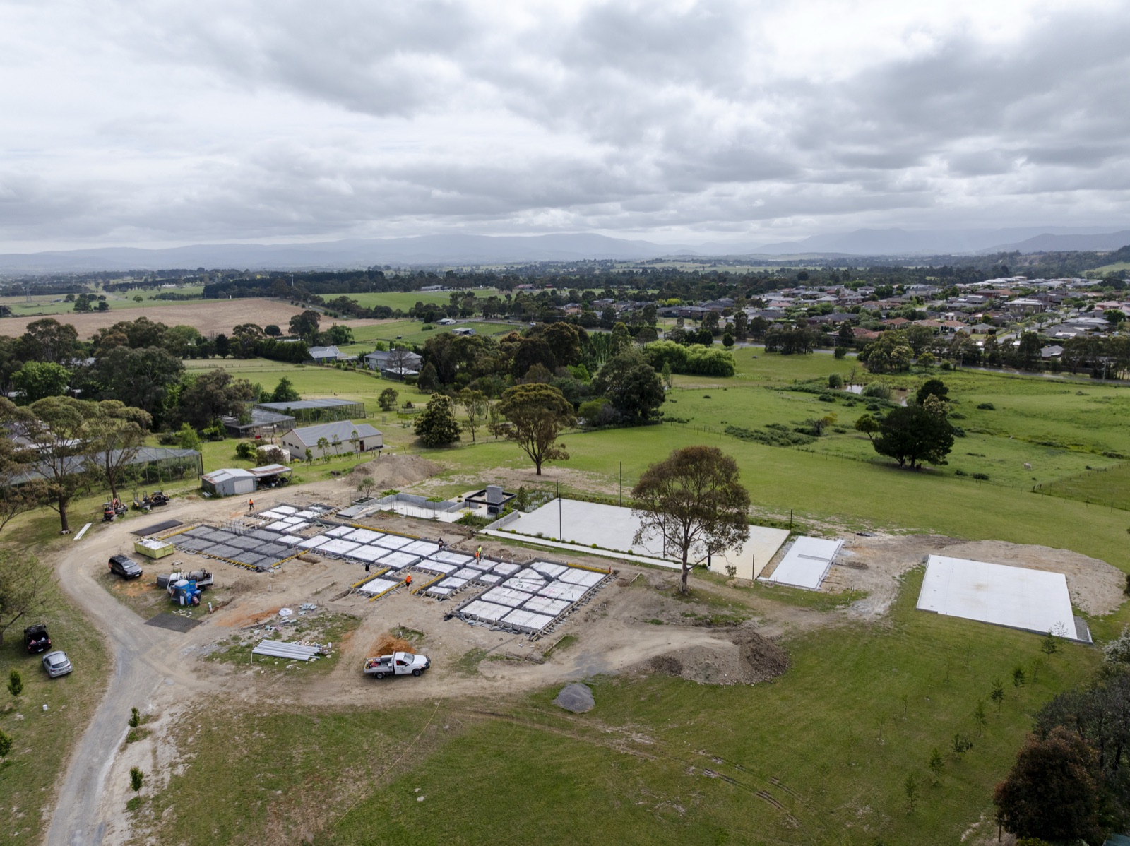 Aerial of a cleared subdivision with the slab grid laid out below the treeline