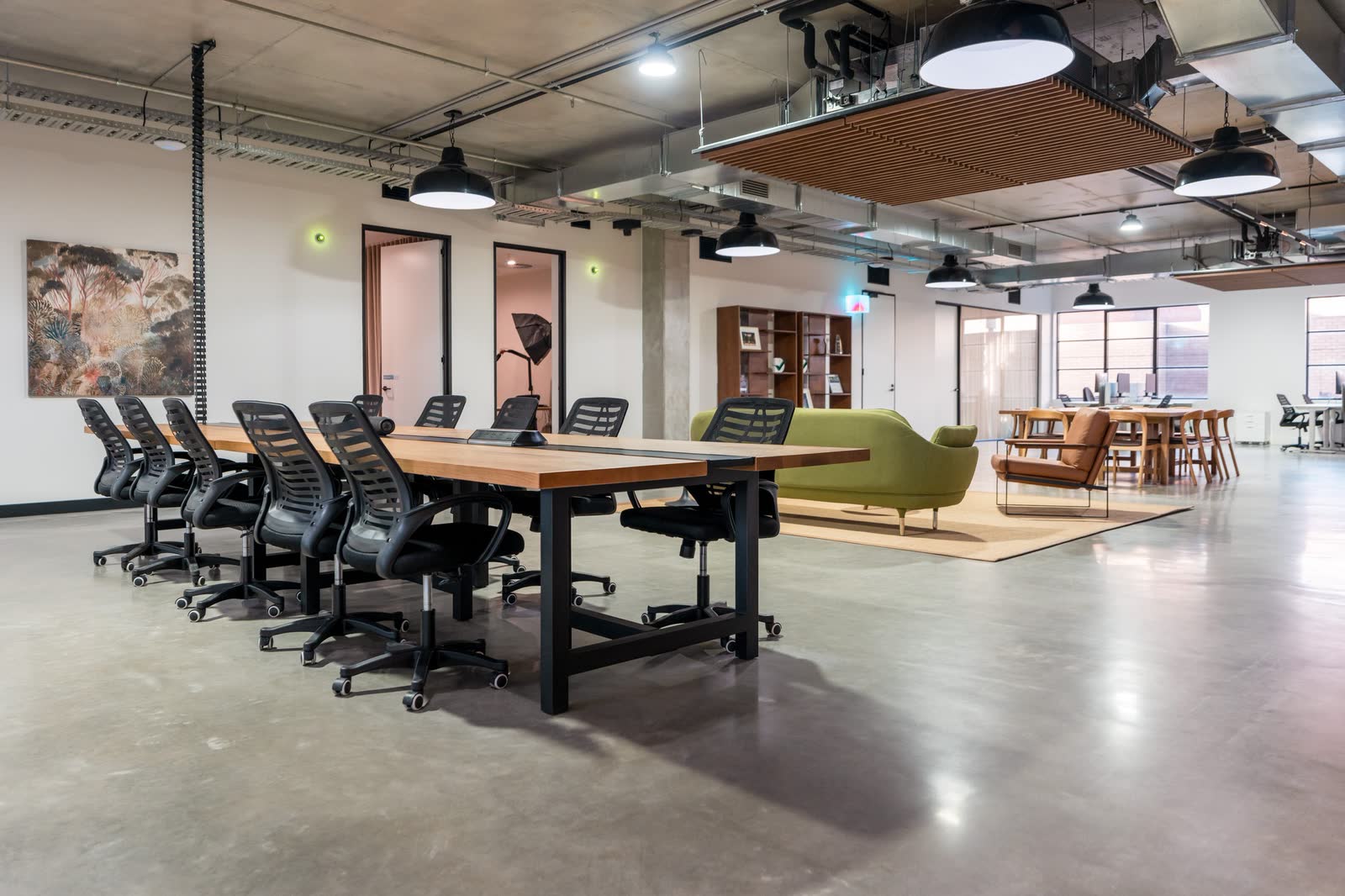 A boardroom table and task chairs in an open plan office fitout