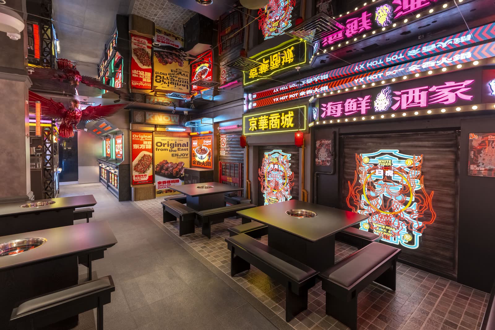 Bench seating and stacked neon signage in a hotpot restaurant