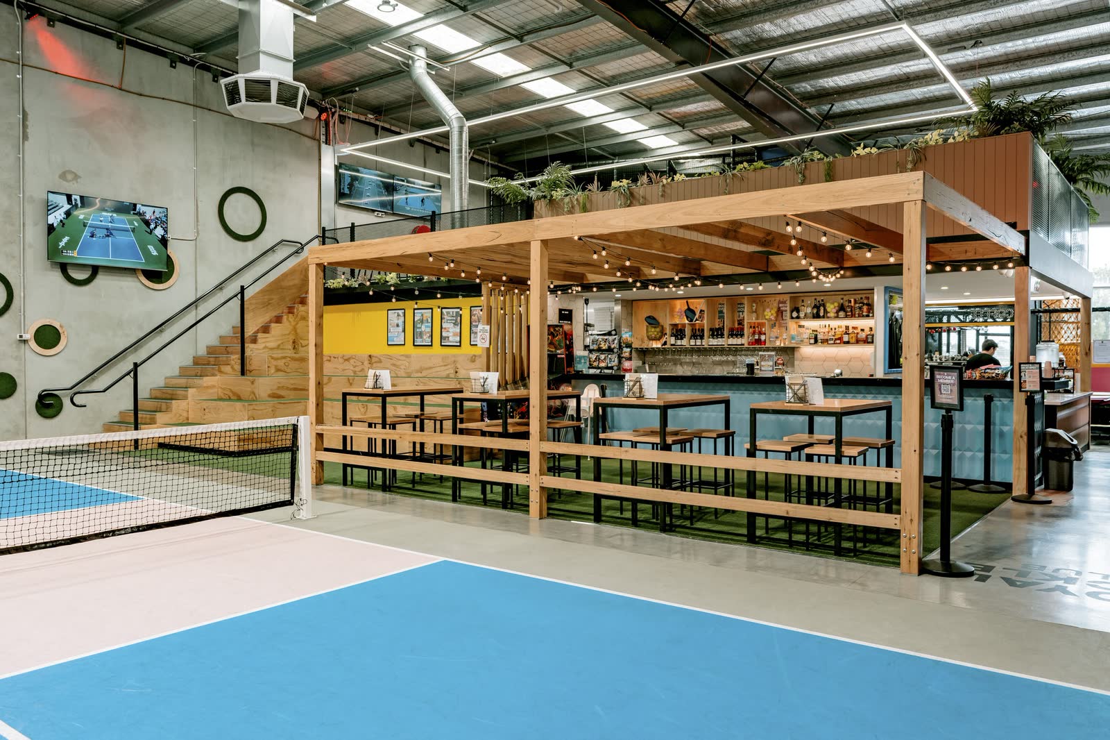 A timber bar and mezzanine overlooking the courts at Royal Pickle Club