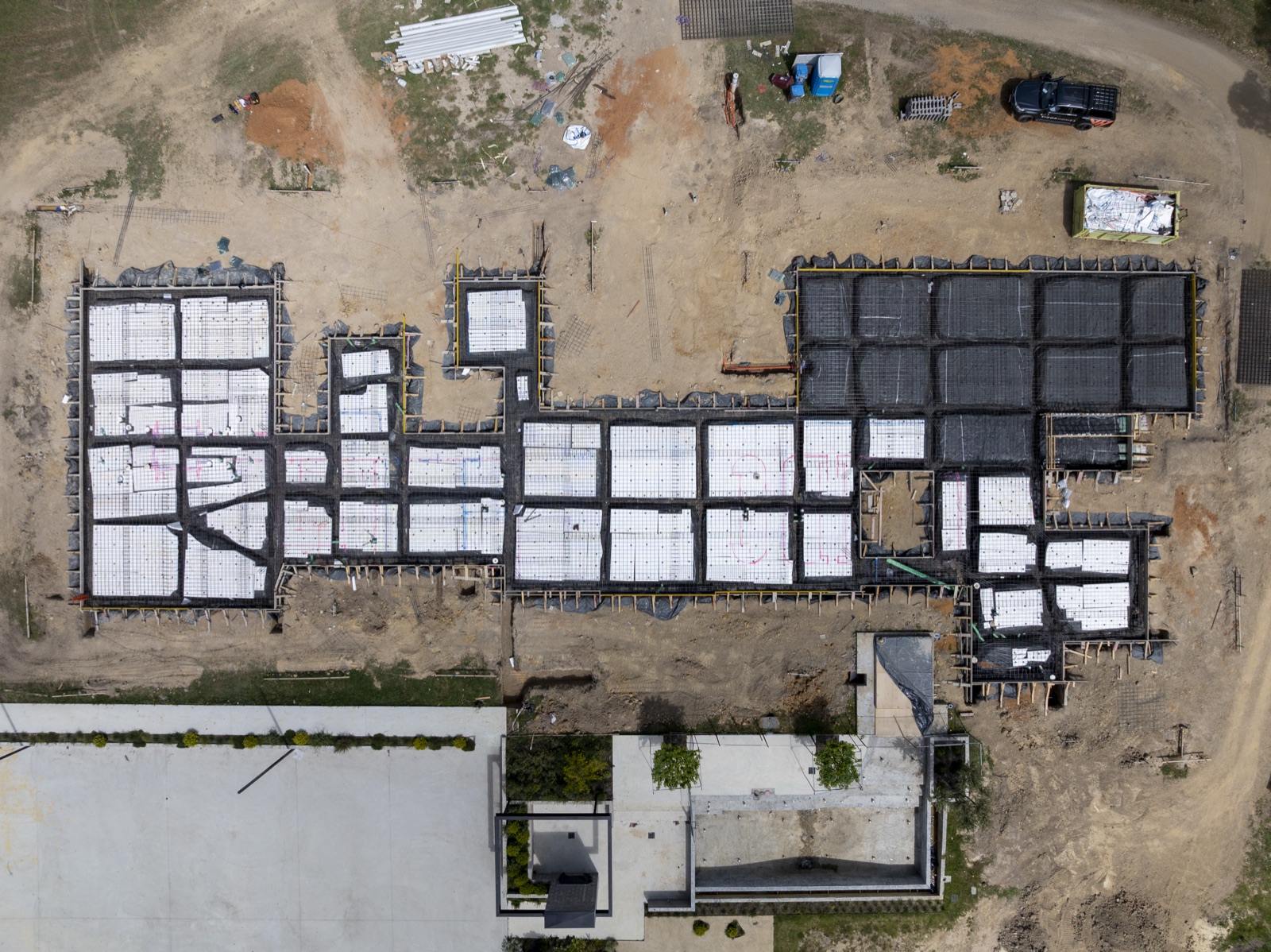 Aerial looking down on poured slabs and footings across a new estate
