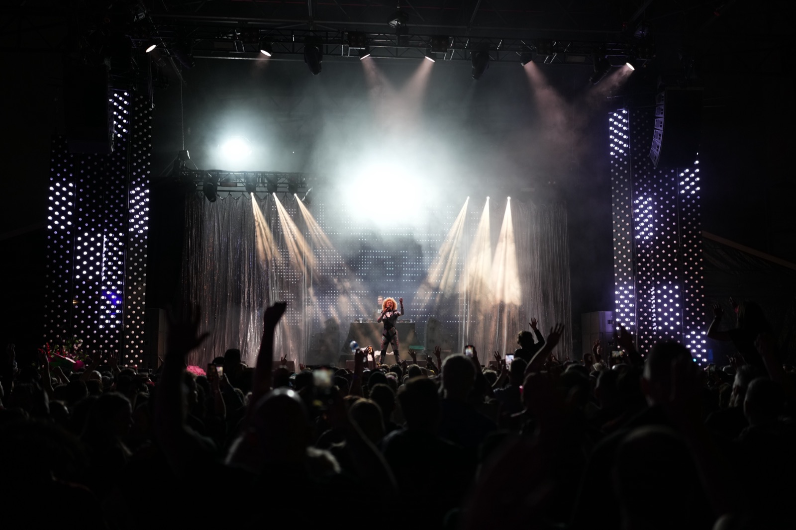 A stage in full light and haze, shot from the back of the room