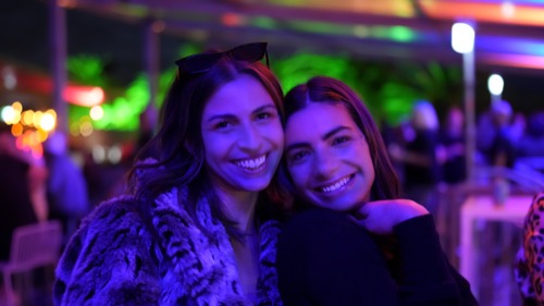 Guests photographed under coloured lighting at an evening brand event