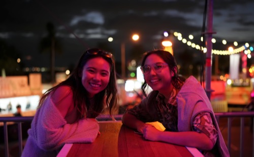 Guests at an outdoor evening event under festoon lighting