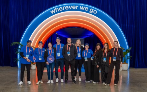 Event team lined up under an illuminated branded arch activation