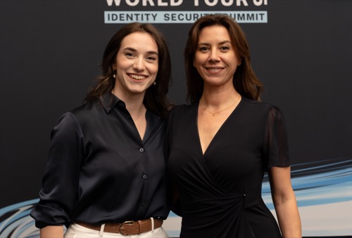 Two delegates photographed at the summit's branded media wall