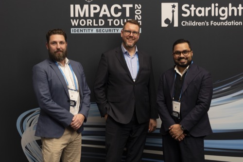 Delegates photographed at a charity partner backdrop during a summit