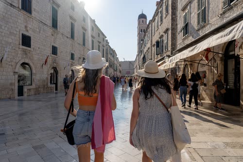 Two women walking the polished limestone of the Stradun, Dubrovnik