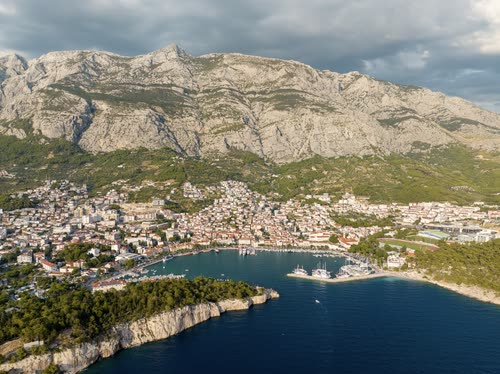 Aerial view of Makarska harbour below the limestone wall of the Biokovo range