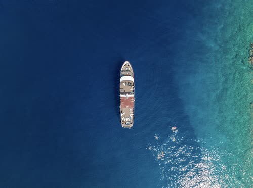 Aerial view straight down on a ship anchored in clear turquoise water, Croatia