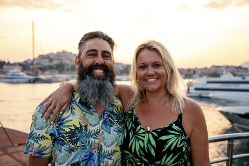 A couple on deck at sunset with the old town behind them, Croatia