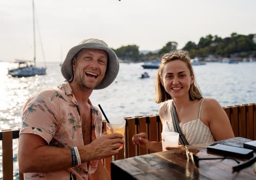 A couple with drinks at a waterfront bar table, Croatia