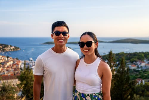A couple above the harbour of Hvar with the Pakleni islands behind, Croatia