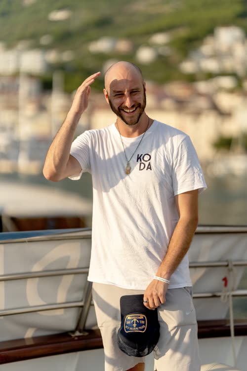 A man in a KODA shirt on the deck of a cruise boat, Croatia