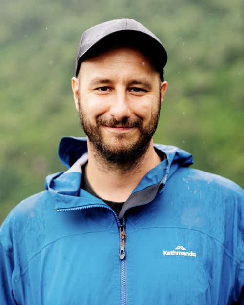 Portrait of Jordy Scott in a blue rain jacket in the Indonesian highlands