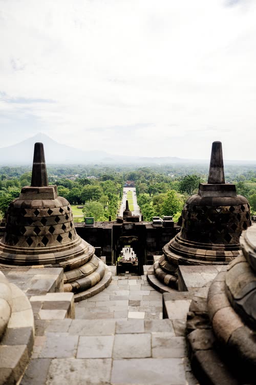 The stone walkway between stupas at Borobudur with a volcano on the horizon, Java