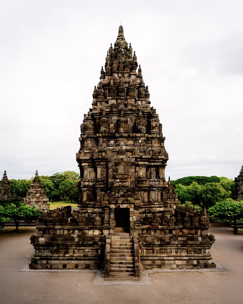 A tall stone candi tower rising above the temple grounds at Prambanan, Java