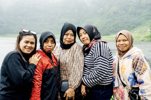 A group of women together at a lake lookout in Indonesia