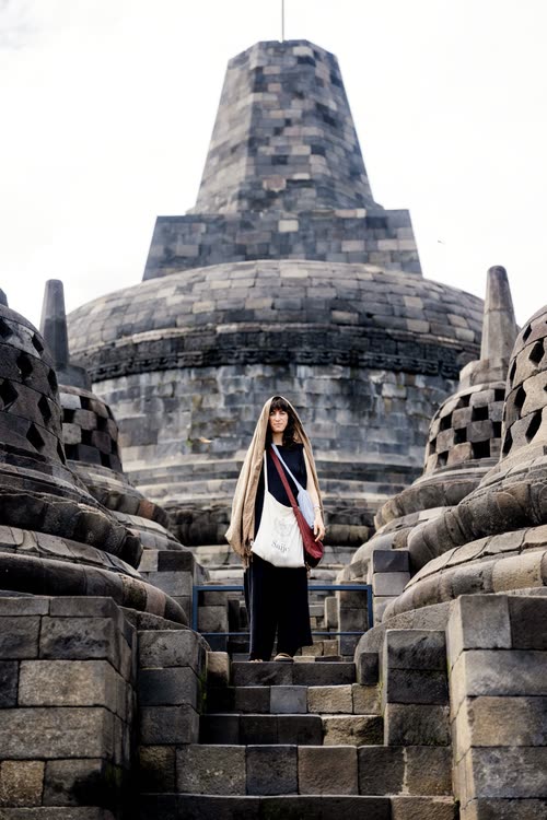 A woman on the steps below the great central stupa of Borobudur, Java