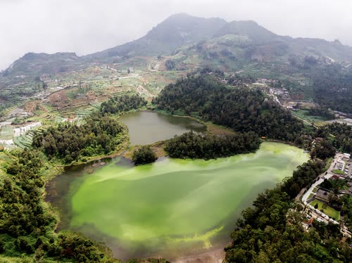 Aerial view of a bright green sulphur crater lake in the Javanese highlands
