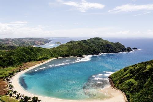 Aerial view of a horseshoe bay and green headlands on the Lombok coast