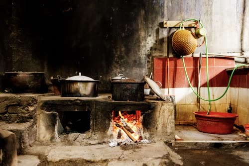 Pots simmering on a wood-fired stove in a village kitchen, Indonesia