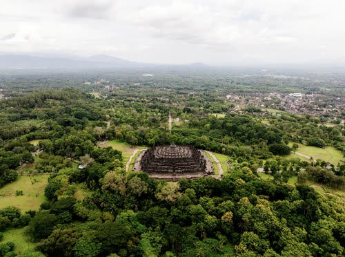 Aerial view of Borobudur set in forest with the plains of Java beyond