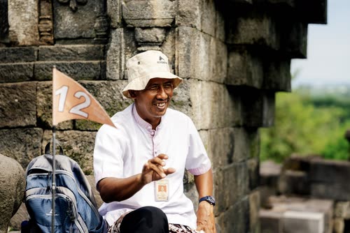 A tour guide with a numbered flag resting against the stonework at Borobudur