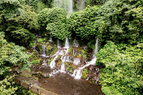 Aerial view of waterfalls fanning down a jungle cliff face, Lombok