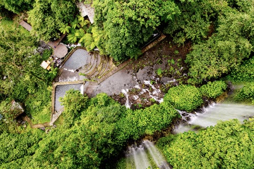 Aerial view looking down on a jungle waterfall and its plunge pool