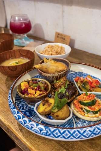 A set lunch of small ceramic dishes, rice, miso and a glass of beetroot juice on a tray