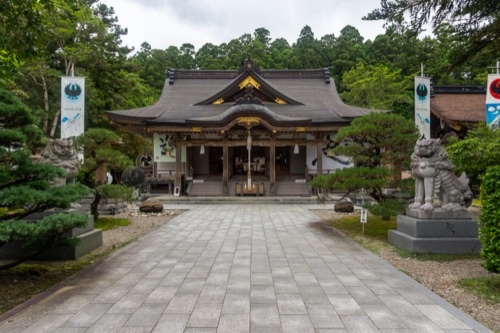 The wide paved approach to Kumano Hongu Taisha between stone guardian lions