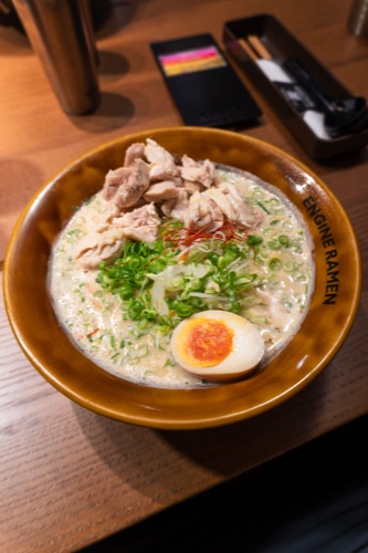 A bowl of tonkotsu ramen with a soft boiled egg and sliced pork