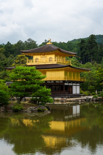 Kinkaku-ji, the Golden Pavilion, reflected in its pond under a soft sky