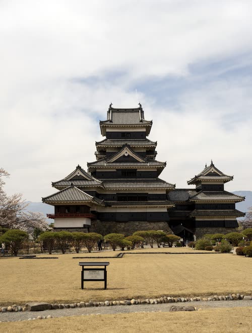 Matsumoto Castle and its smaller turret seen across the dry outer grounds