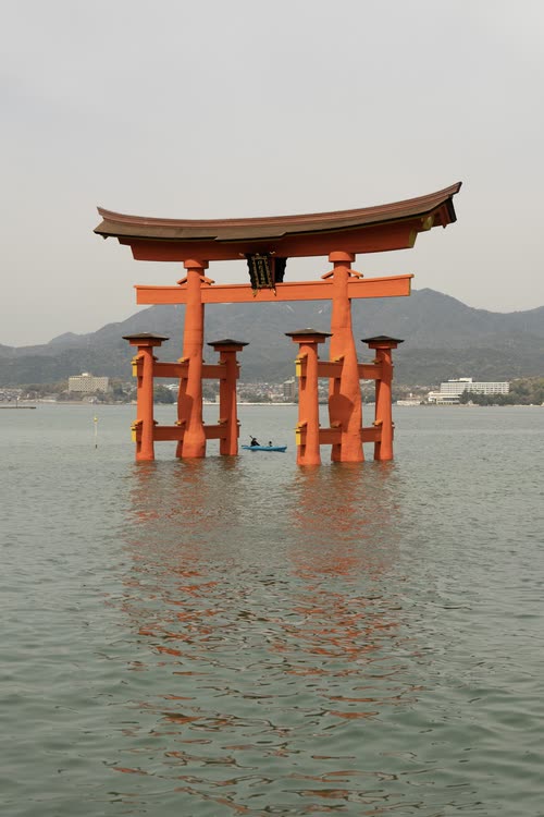 The vermilion torii gate of Itsukushima standing in the sea by day, Miyajima