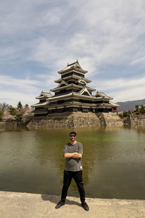 Jordy Scott standing at the moat edge in front of Matsumoto Castle