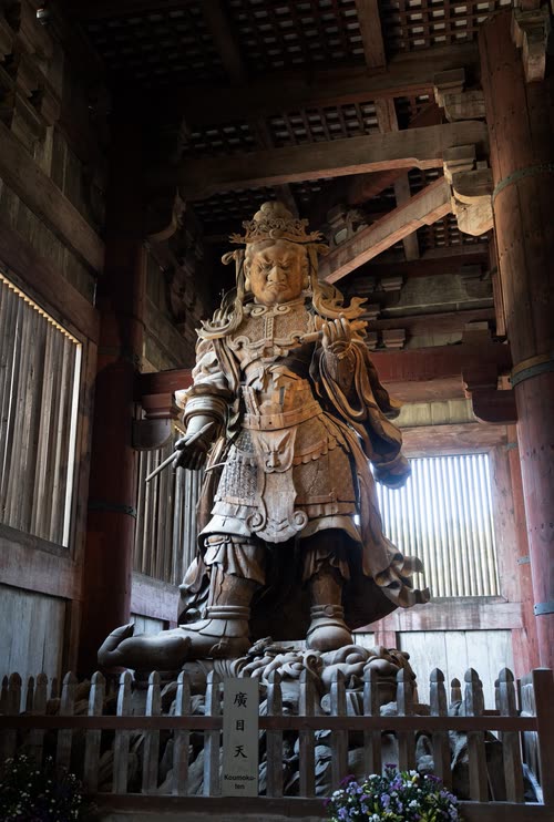 A carved wooden guardian figure standing inside a temple gate at Todai-ji