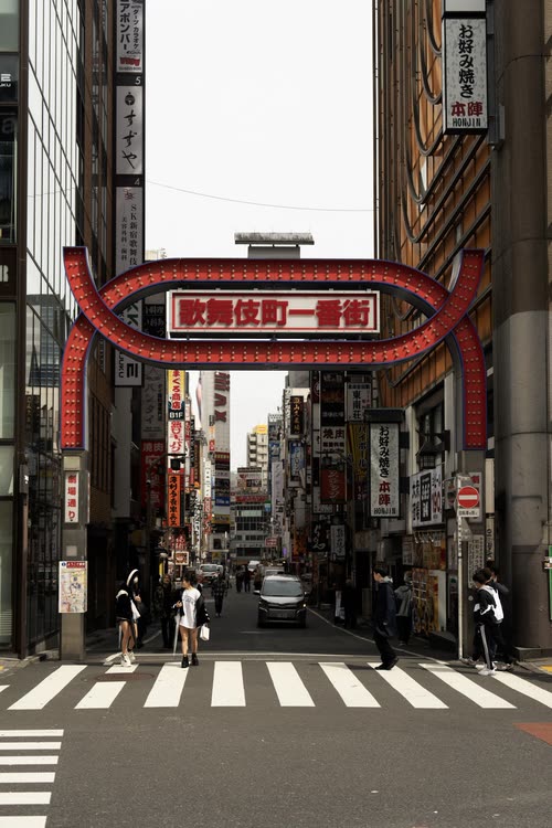 The Kabukicho Ichibangai gate and its signage-covered street by day, Shinjuku