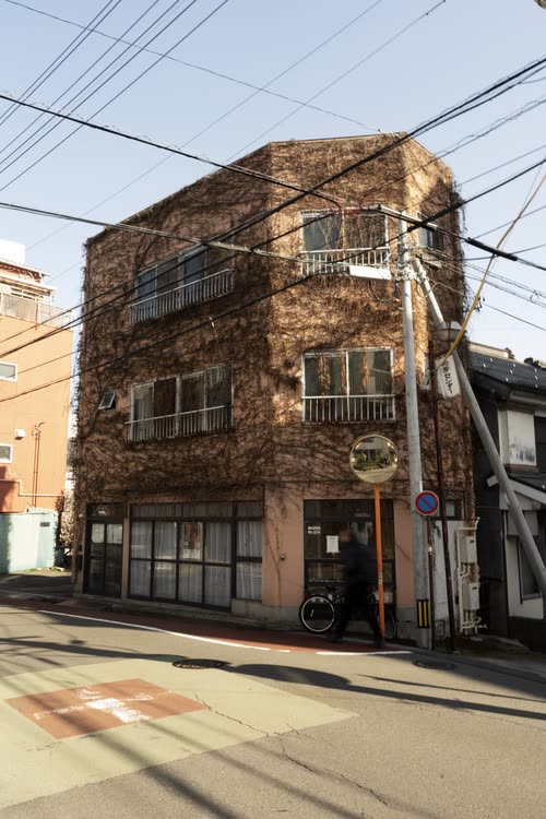 A weathered corner building beneath a tangle of overhead power lines