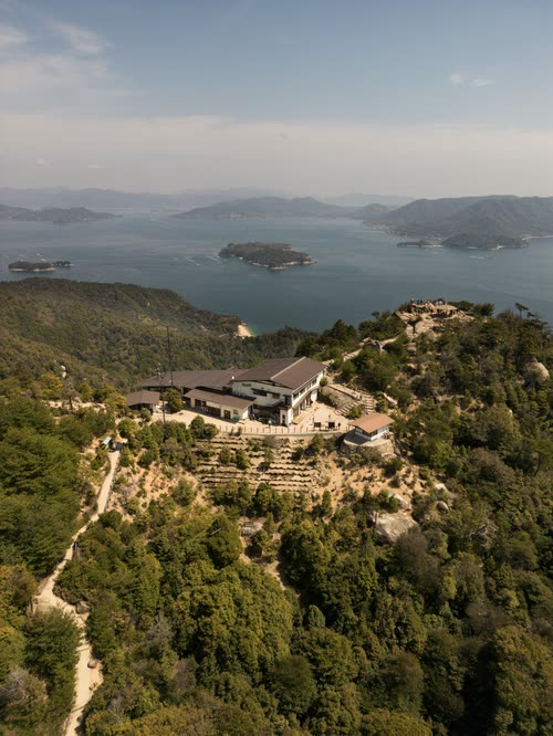 Aerial view of a forested island summit above the islands of the Seto Inland Sea