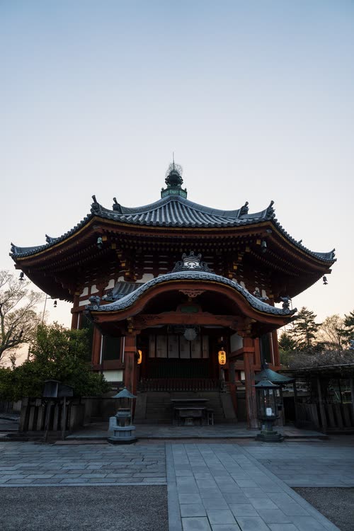 An octagonal temple hall with deeply curved eaves at first light