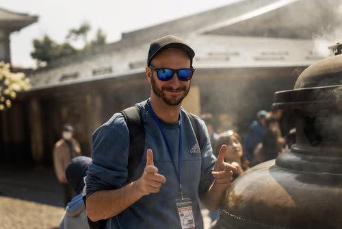 Jordy Scott giving two thumbs up beside a smoking bronze incense burner