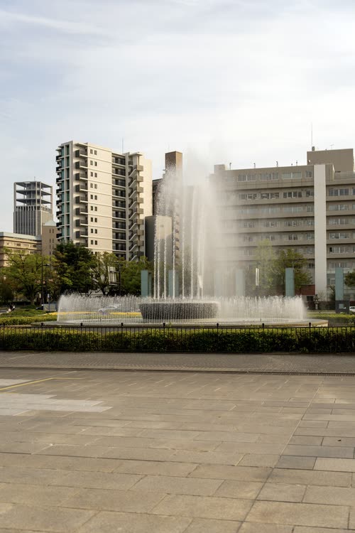 The Fountain of Prayer playing in front of city buildings in Hiroshima