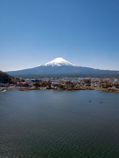 Snow-capped Mount Fuji rising above Lake Kawaguchi and its lakeside town